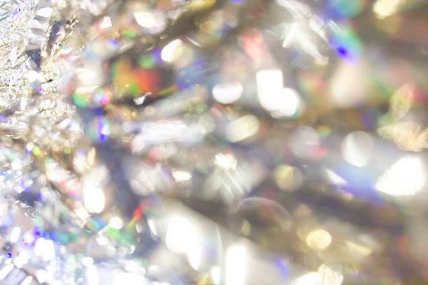 Abstract shimmering background with bright multicolored bokeh and sparkling light reflections, creating a festive holiday atmosphere with glowing defocused highlights