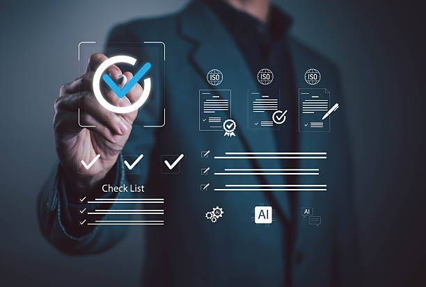 istock Businessman pointing at digital checklist with check mark icon, symbolizing approval, verification, compliance, ISO certification, quality assurance, audit, management, professional business success. 2248304235