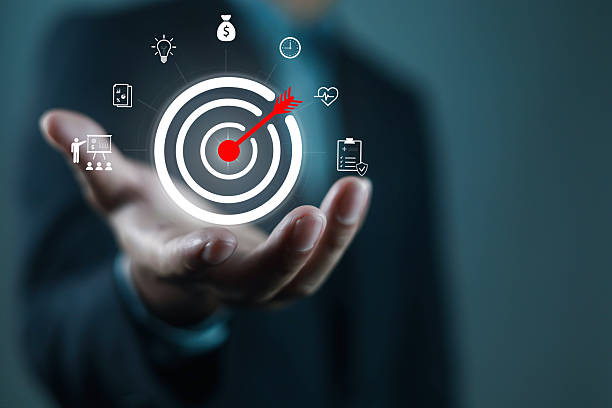 Target with arrow hitting bullseye floating above hand, symbolizing business goal, strategy, focus, success, marketing, achievement, and planning for professional growth and performance.