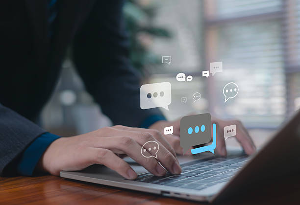 istock Businessman typing on laptop with digital chat bubbles, representing online communication, messaging, customer support, social interaction, and modern digital connection. 2248304430