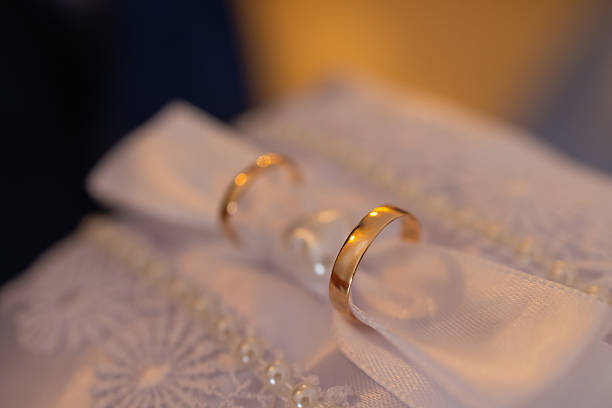 istock two gold wedding rings on a pillow. 2248305468