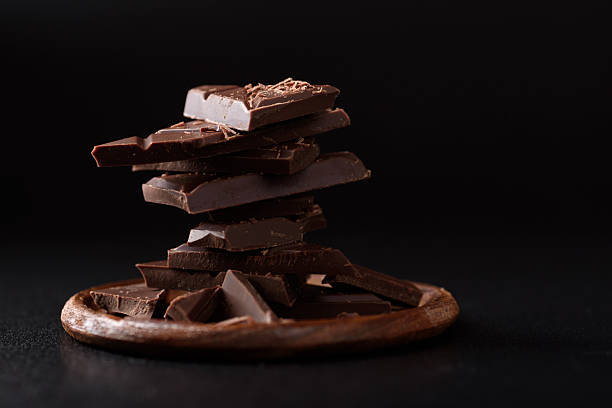 istock Small pieces of chocolate bars are arranged on a black background 2248311463