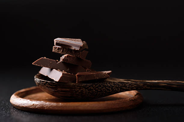 istock Small pieces of chocolate bars are arranged on a black background 2248311467