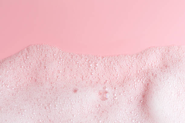 istock White fluffy foam on pink background, top view. Space for text 2248311736