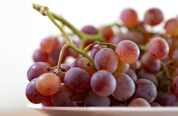 istock A bunch of purple grapes on a white plate 2248312147