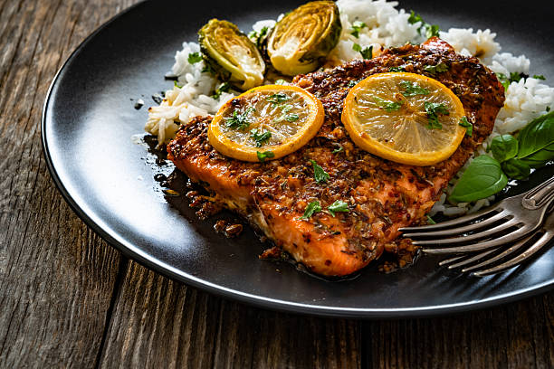 istock Baked salmon with white rice on wooden table 2248314080