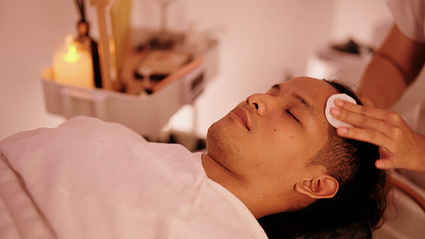 istock Spa therapist gently cleansing a male client’s face with cotton pads before beginning the facial massage 2248314113
