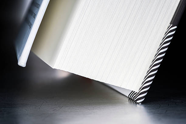 Edge of a closed hardcover book on a metal surface