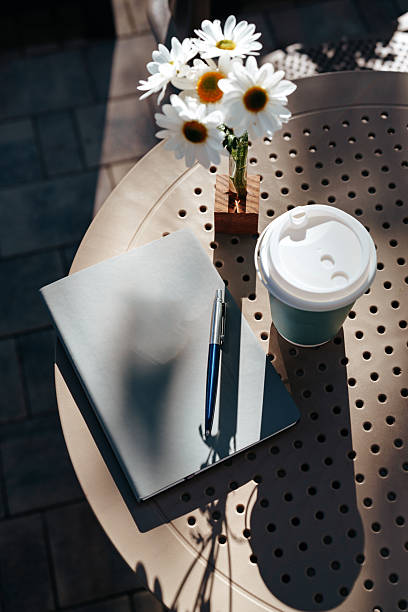 istock Coffee and notebook on a sunny table with flowers during a peaceful afternoon 2248318196