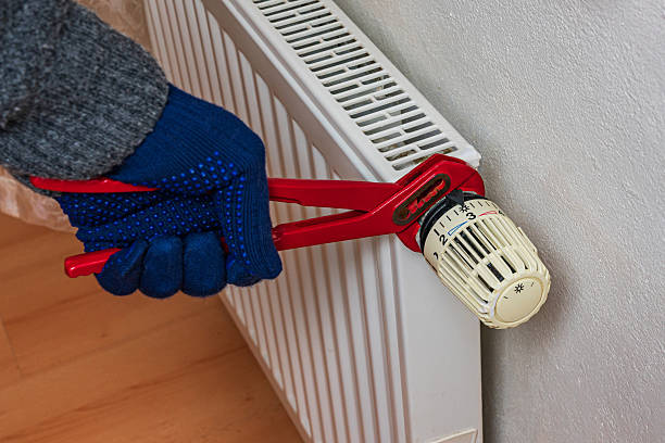 istock Adjusting heating radiator valve in a home environment during winter 2248319407