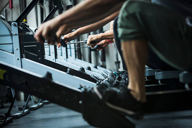 Low angle view of athletes strength training in gym, rowing machine, Whistler, B.C.