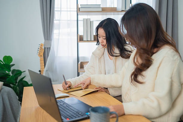 istock Two Women Collaborating on Creative Ideas in a Cozy Workspace with Laptop, Notebook, and Indoor Plants in Bright Natural Light 2248321261