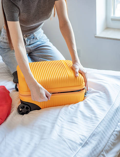 istock Woman packing suitcase on bed preparing for travel 2248322768