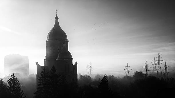 Misty Church Silhouette at Dawn. Foggy urban scene with a Church silhouette, electrical pylons, and a distant apartment block.
