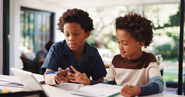 istock Book, homework and children in house with education, learning or studying for test together. Writing, help and boy kids with knowledge for school assignment, assessment or exam by desk in apartment. 2248324626