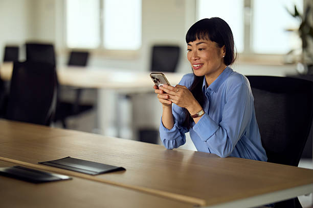istock Asian Woman In Office Using Smartphone At Workspace For Professional Communication And Modern Business Environment 2248324763