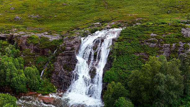 istock Aerial view of Three Waters Waterfall cascading down rocky cliffs surrounded by lush greenery in Glencoe, Scottish Highlands, Scenic nature landscape with flowing water and wilderness concept 2248330445