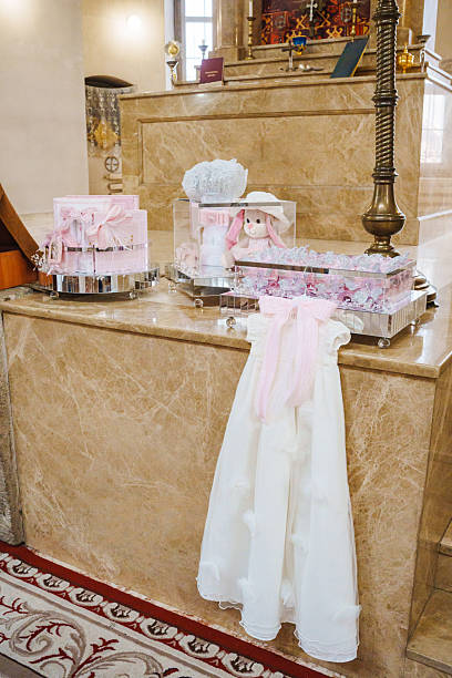Delicate decorations and a white gown are set up in a sacred space, signaling preparations for a significant ceremony. A soft ambiance fills the room.