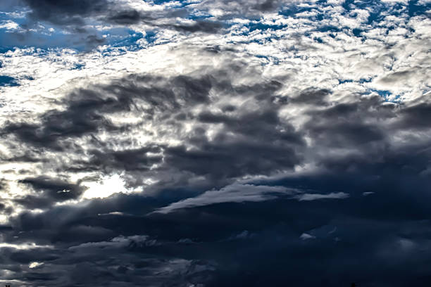 Cloudy sky with various blue and gray shades, subtle play of light and shadow creates a calm atmosphere.