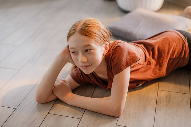 istock A cute red-haired girl is lying on the kitchen floor. Transition age. Puberty 2248340818