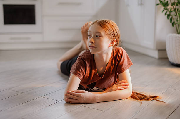istock A cute red-haired girl is lying on the kitchen floor. Transition age. Puberty 2248340821