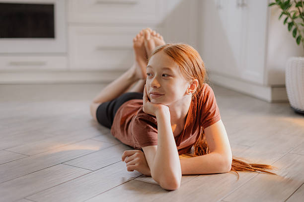 istock A cute red-haired girl is lying on the kitchen floor. Transition age. Puberty 2248340825