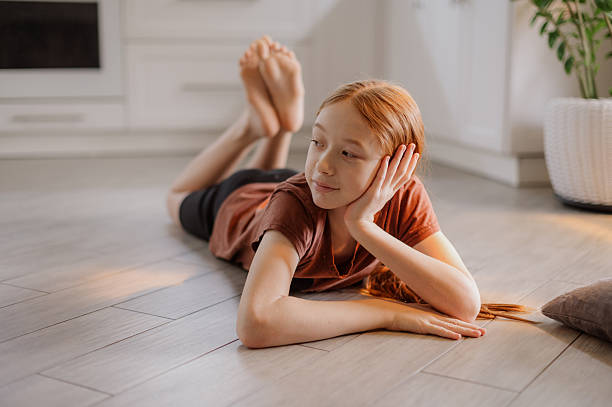 istock A cute red-haired girl is lying on the kitchen floor. Transition age. Puberty 2248340826
