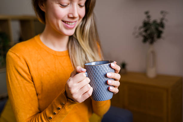 istock Young woman enjoying warm coffee mug at home 2248344095
