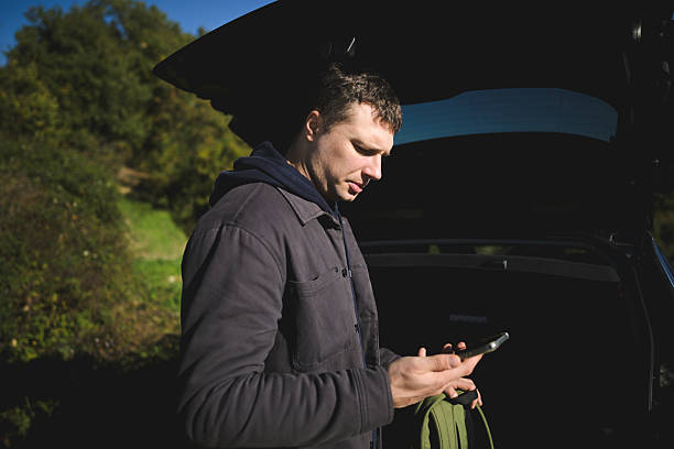 istock Man checking phone near car in nature 2248344427