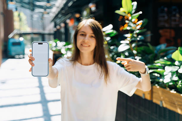 istock Woman presenting smartphone with blank screen outdoors 2248344800
