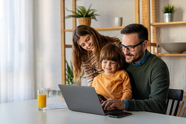 istock Father with kids having fun online with application watching video cartoon or playing game on laptop 2248347061