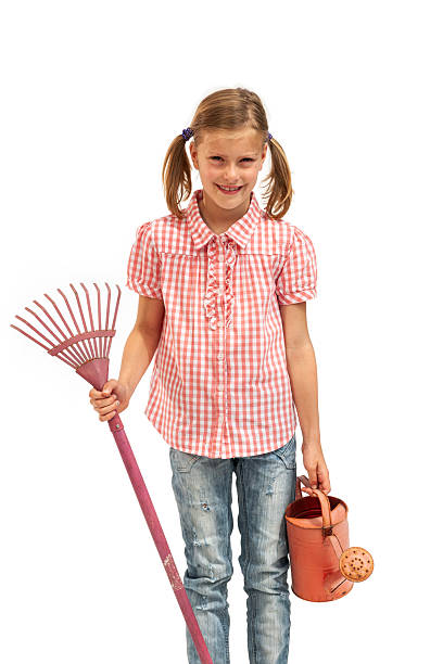 Girl holding a watering can and a rake, on a white background.