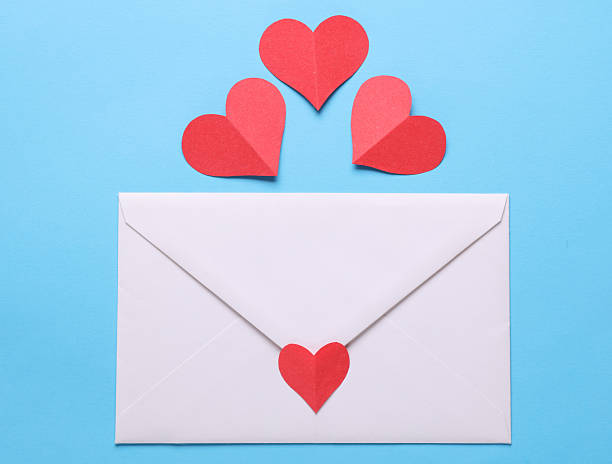 istock White envelope with paper heart on blue background. Love concept 2248348954