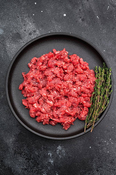 istock Ground lamb mutton on black dish against textured dark backdrop great for kitchen prep visuals high quality food photography and stock content. 2248352969