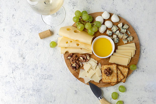istock Gourmet cheese platter with grapes, nuts, and honey on rustic wooden board 2248355738