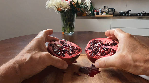 Hands hold cut pomegranate
