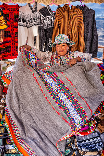 Peruvian woman selling souvenirs in her shop near Colca Canyon, Peru. Colca Canyon is a canyon of the Colca River in southern Peru. It is located about 100 miles (160 kilometers) northwest of Arequipa. It is more than twice as deep as the Grand Canyon in the United States at 4,160 m. However, the canyon's walls are not as vertical as those of the Grand Canyon. The Colca Valley is a colorful Andean valley with towns founded in Spanish Colonial times and formerly inhabited by the Collaguas and the Cabanas. The local people still maintain ancestral traditions and continue to cultivate the pre-Inca stepped terraces.