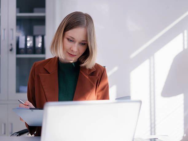 istock Business women hand working with tablet and laptop computer with documents on office desk in modern office. 2248360897