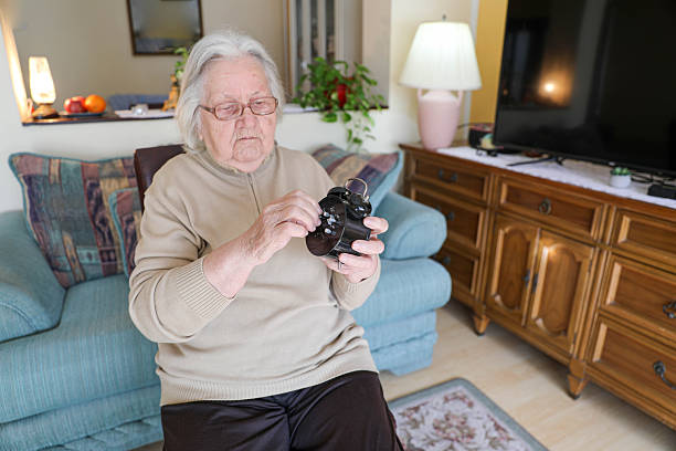 Elderly 80+ Woman Carefully Adjusting a Classic Analog Alarm Clock While Sitting Comfortably at Home, Representing Time Management, Daily Routine, Memory Care, and Aging Lifestyle.