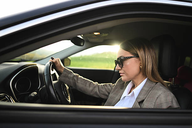 istock Young woman driving car during sunset commute 2248362106