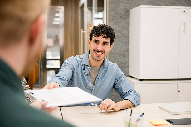 istock Businessman passing documents to colleague in office meeting 2248363815