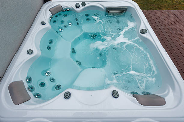 istock Outdoor hot tub with active hydrotherapy jets on deck next to wall 2248364549