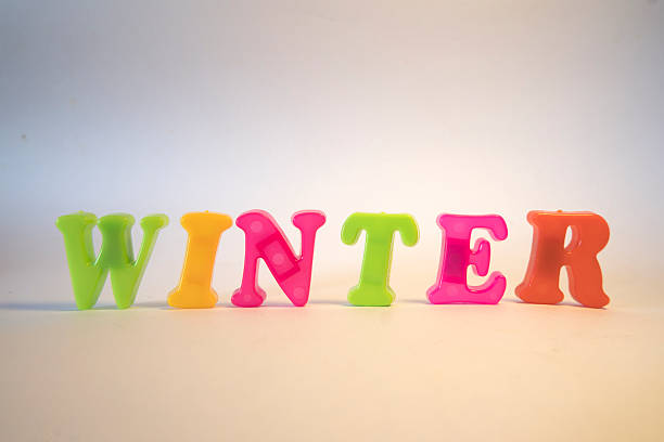 WINTER Text Made of Colorful Plastic Letter Candles on White Background