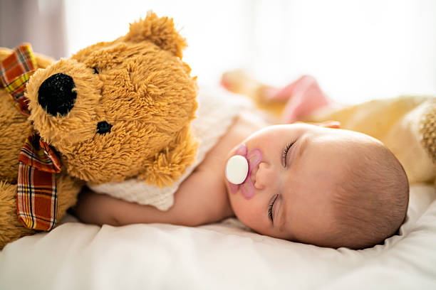 4 month baby sleeping on a white bed at home
