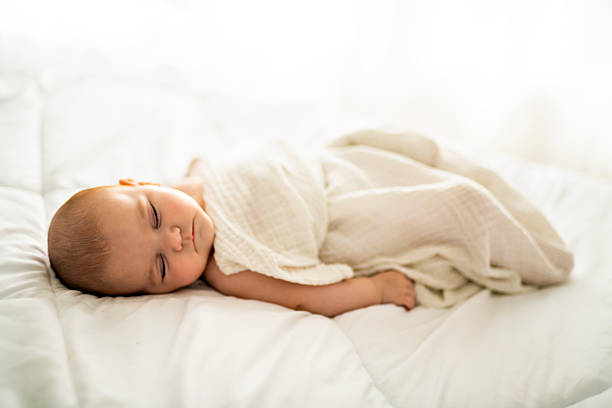 istock A 4 month baby sleeping on a white bed at home 2248367092