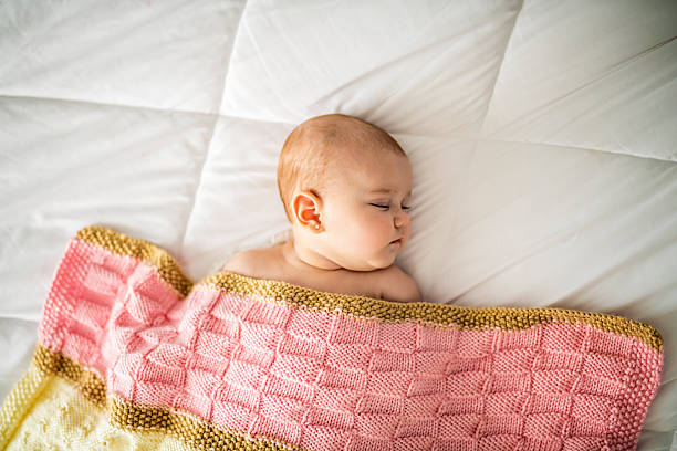4 month baby sleeping on a white bed at home