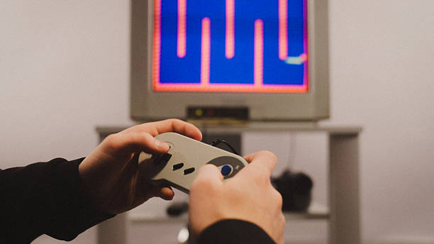 istock Siblings playing a video game on an old school console on a CRT TV. Portable CD player on the floor 2248368034