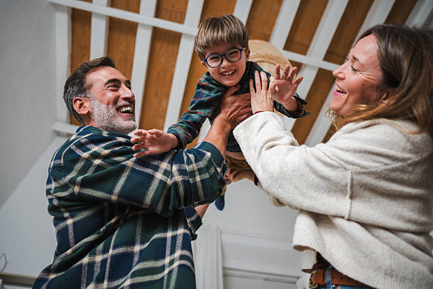 istock Happy parents playing with son tossing him in air 2248368122