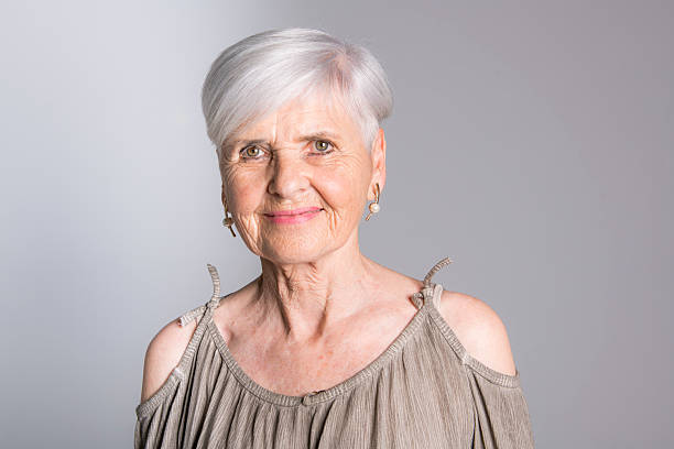 istock elderly woman on studio dark gray background 2248369769