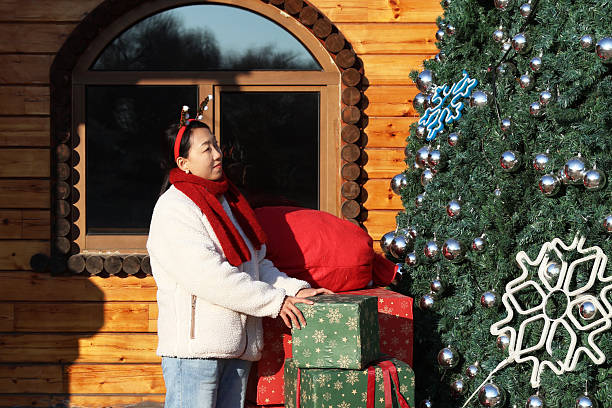 istock Asian women holding gift boxes in front of a Christmas tree. 2248370724